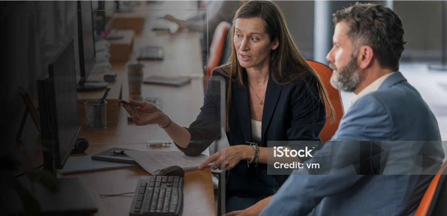 Business woman explaining something on a screen to a man sat next to her